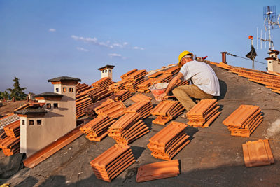 A roofing worker preparing the surface for the replacement project.